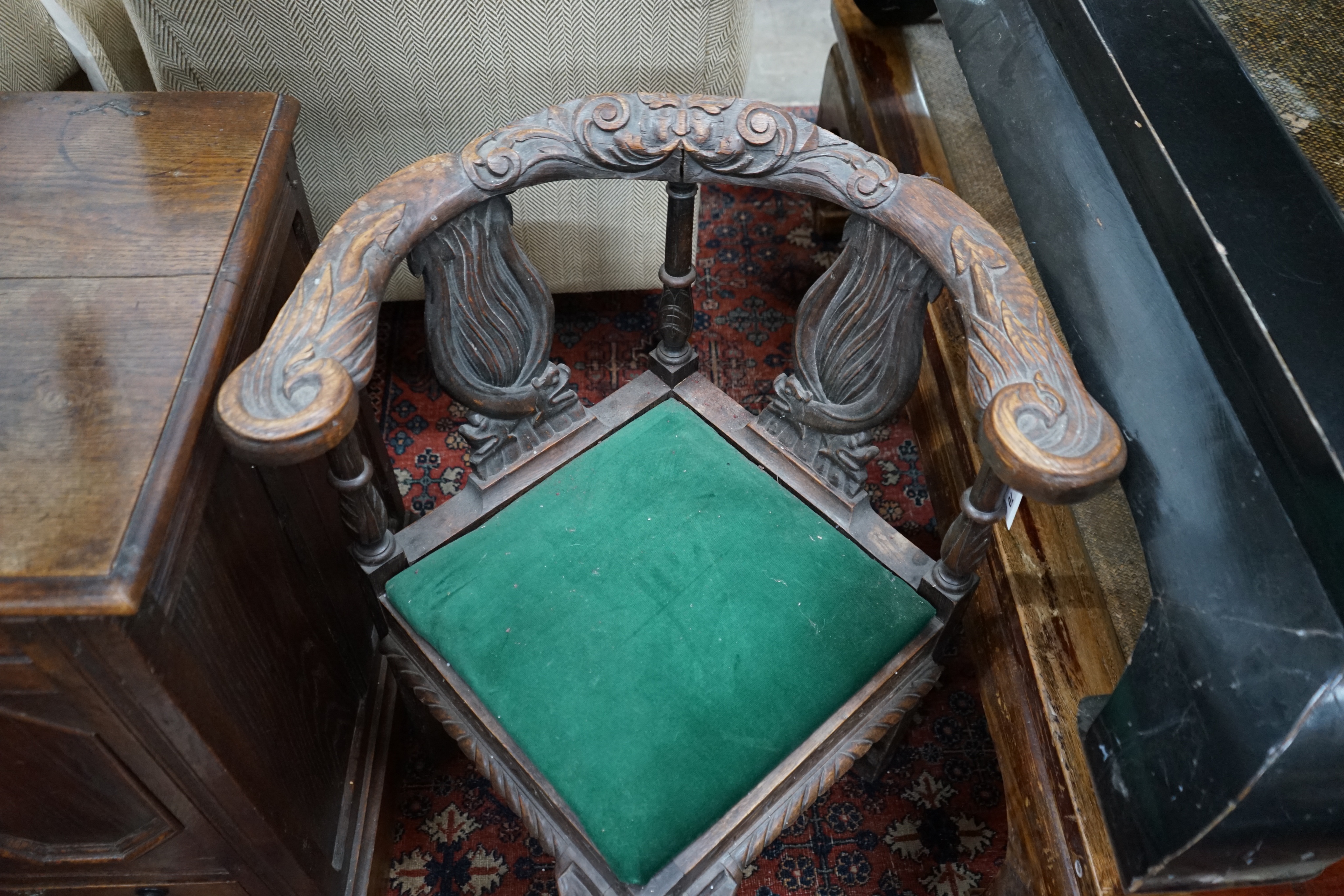 A Victorian carved oak corner elbow chair